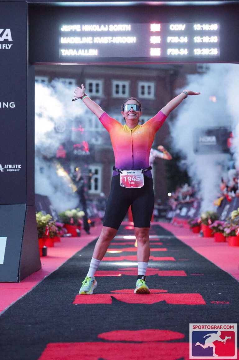 Tara striking a magnificent pose at the finish line - "YOU ARE AN IRONMAN!"